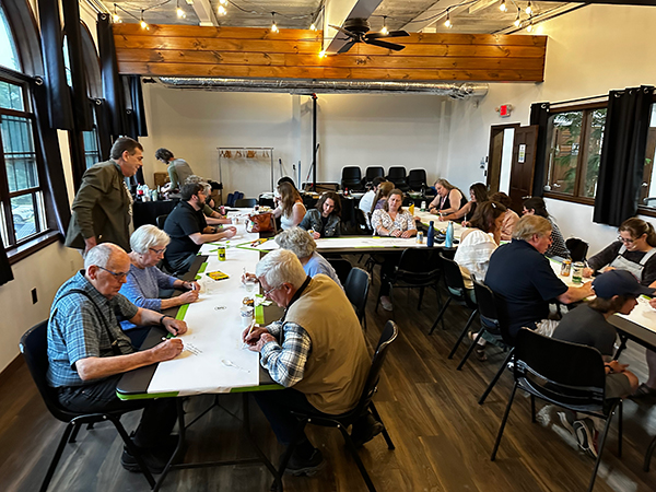 Community members gathered around tables for the monthly space on Main Democracy dinner.