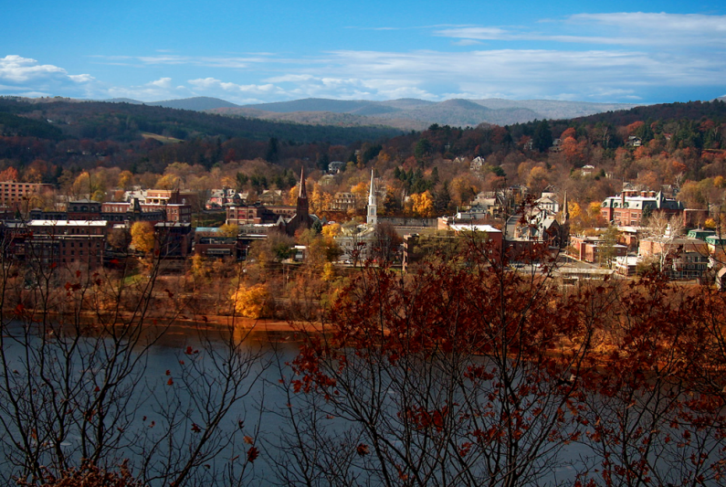 a drone view of Brattleboro VT with the CT River in the foreground and mountains in the background