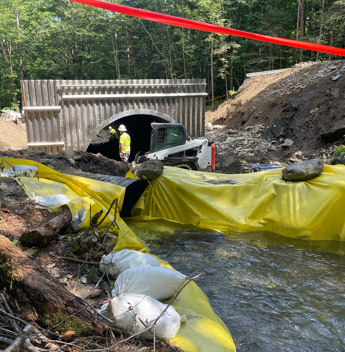 Construction scene with repair work on a culvert damaged during the July 2023 flooding.