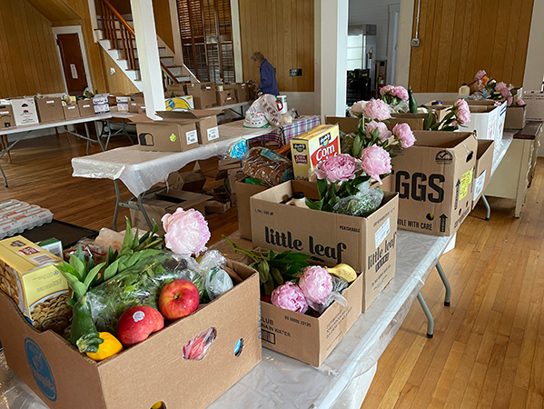 Pink peonies accompany food in a box from a Vermont food pantry.