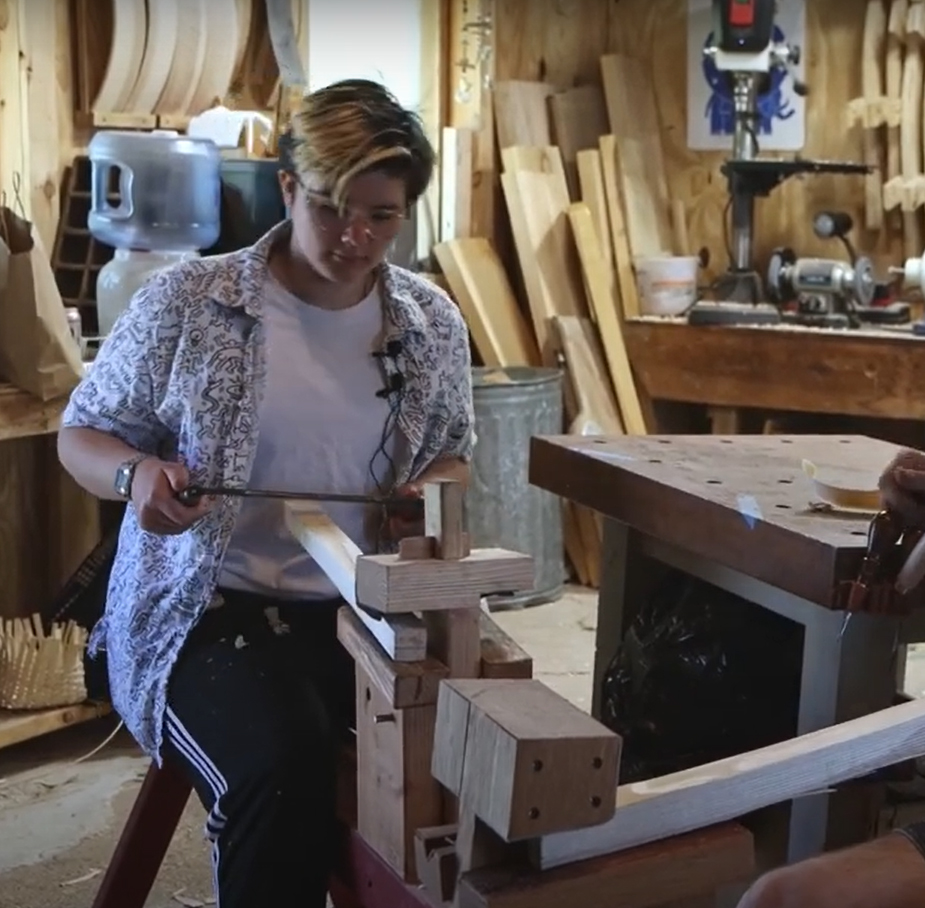 A teenager works in a woodshop.