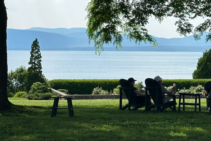 two people sitting on lake front adirondaks