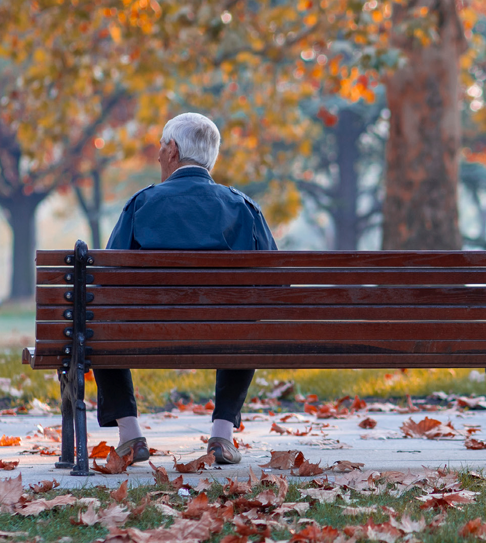 A person sits on a park bench alone.