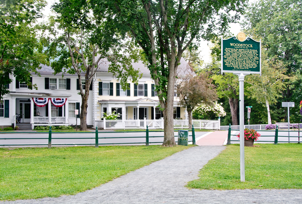 historic buildings across from a town green with a sign about the history of Woodstock