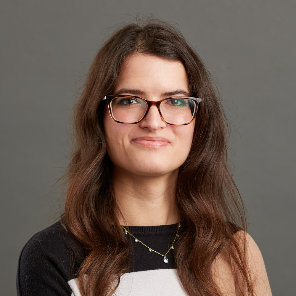 headshot of a person with long brown hair and glasses