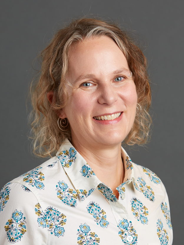 a woman wearing a button up white shirt with a blue & yellow floral pattern