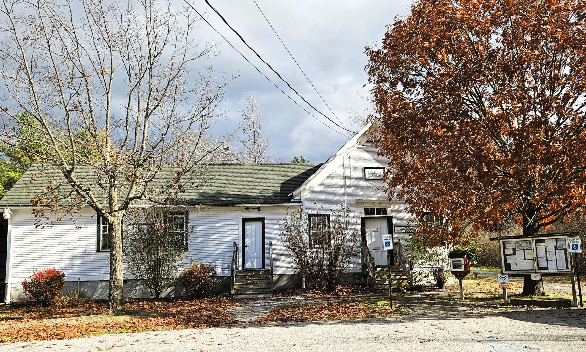 Town office in a small Vermont town with a large tree with colorful leaves in front.