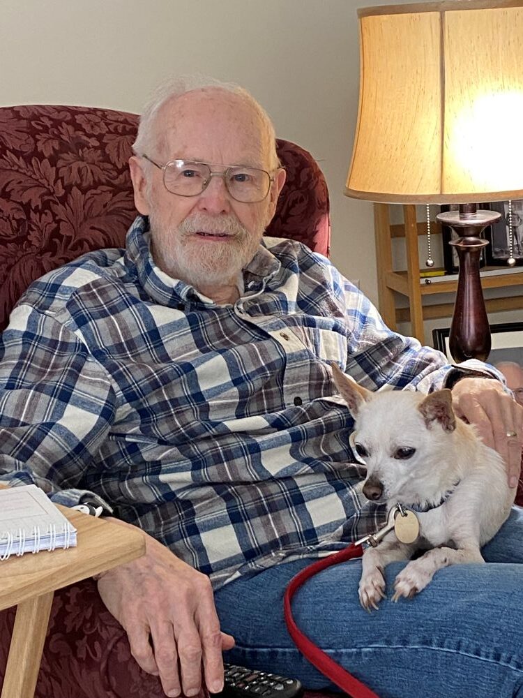 Leonard sitting in a chair with his dog, Willy