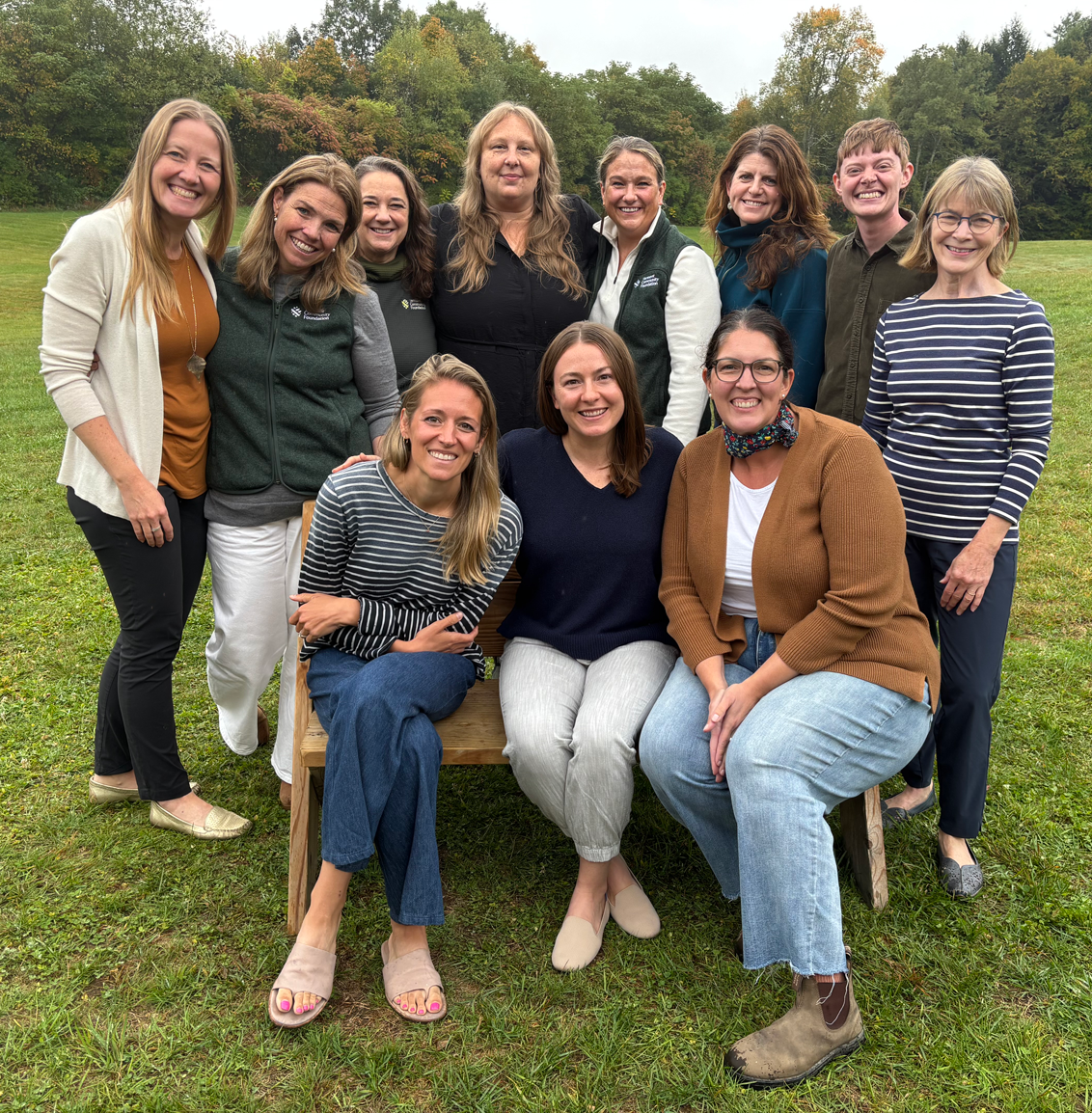11 smiling people posing for a department photo