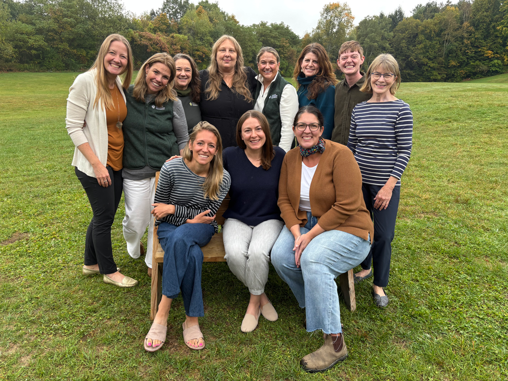 11 smiling people posing for a department photo