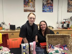 a young maker standing in front of their table at the maker market