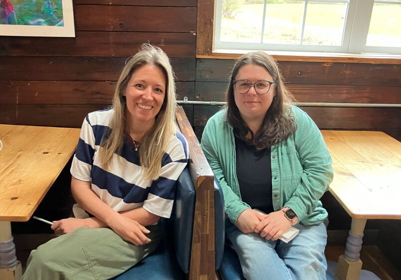 two VCF staff members sitting together and smiling